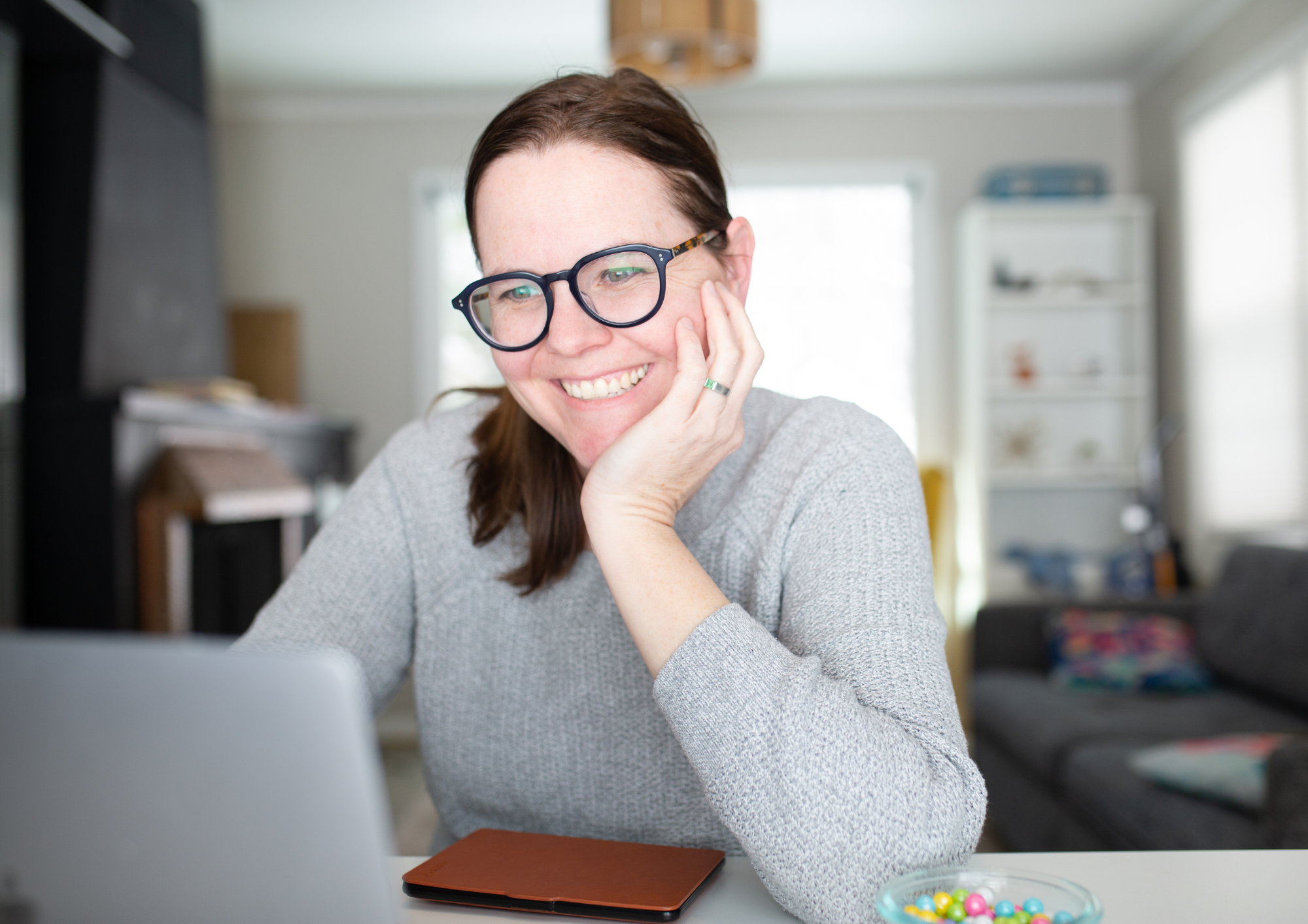 Woman smiling at laptop during a check-in call